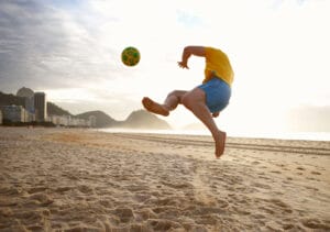 Mid adult man playing soccer on Copacabana beach, Rio De Janeiro, Brazil